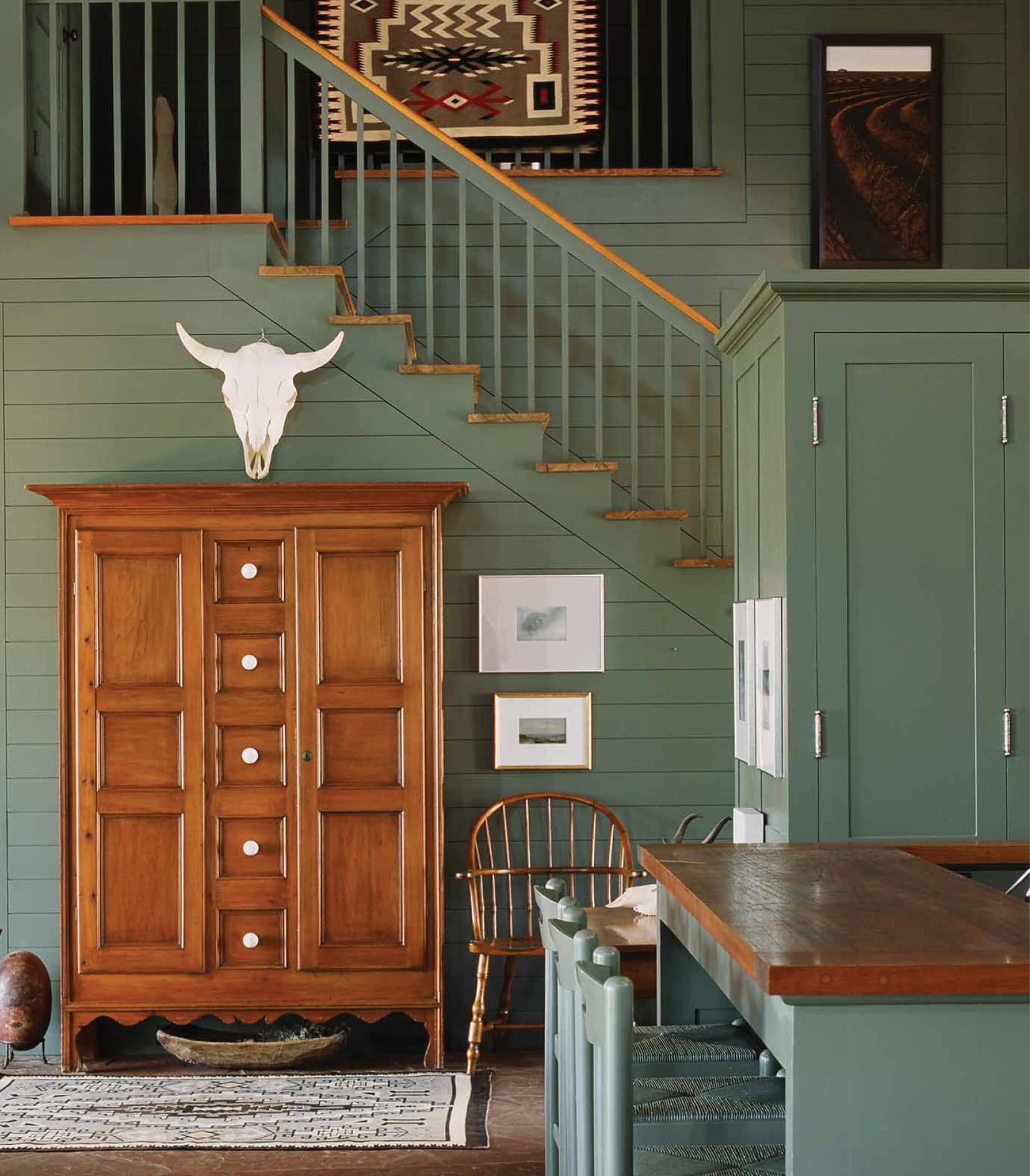 Green interior room with staircase, armoire and cow skull