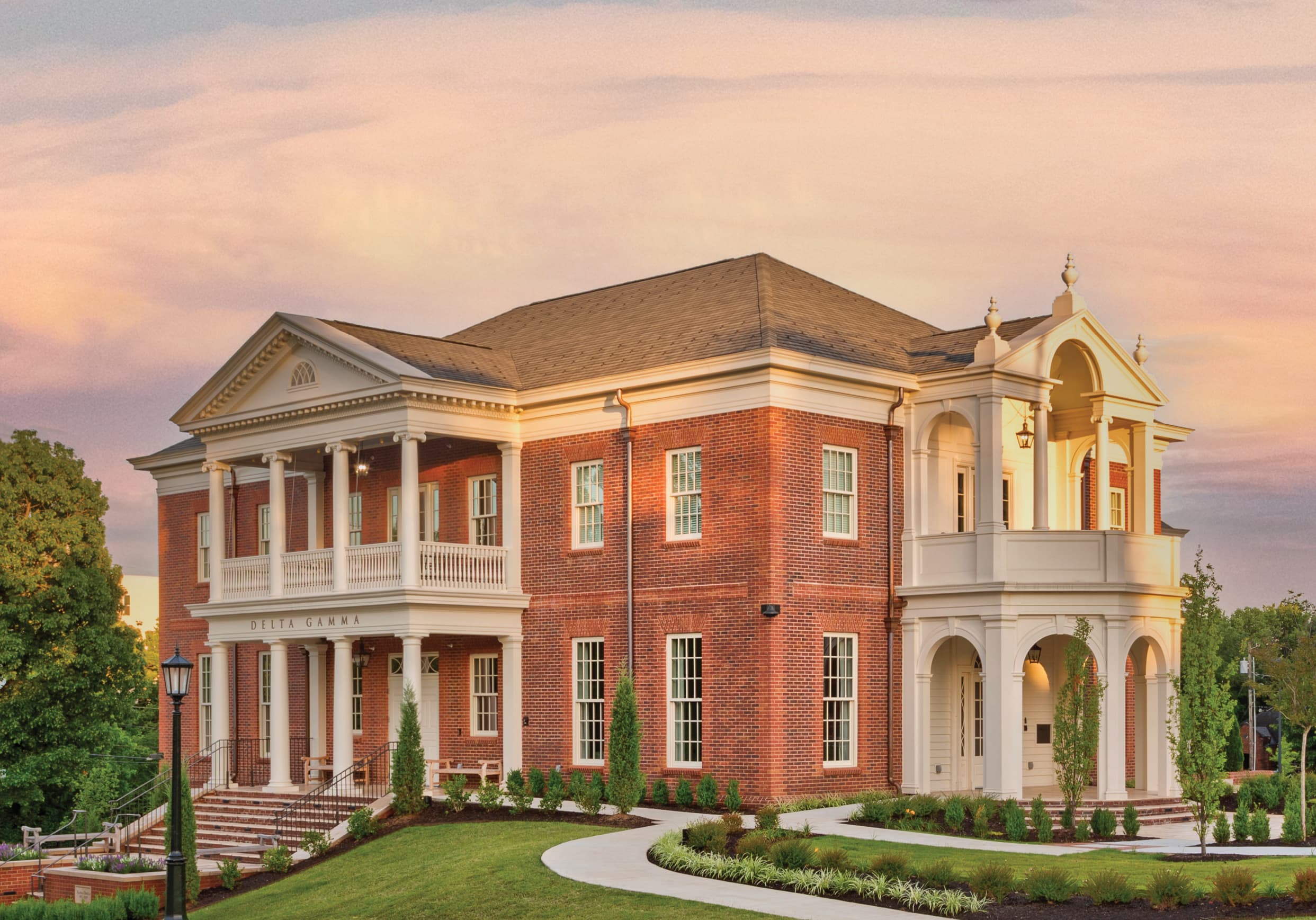 Exterior view of the brick sorority house with large, columned porches and balconies