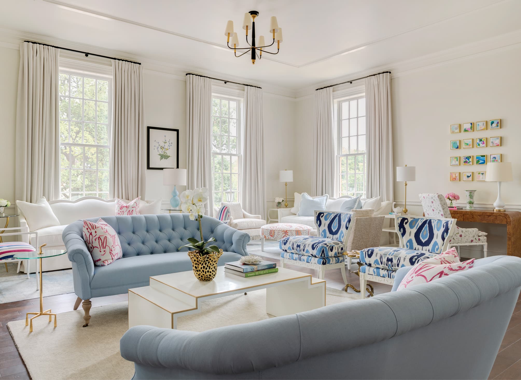 Sitting area with white walls, large windows and light blue furniture