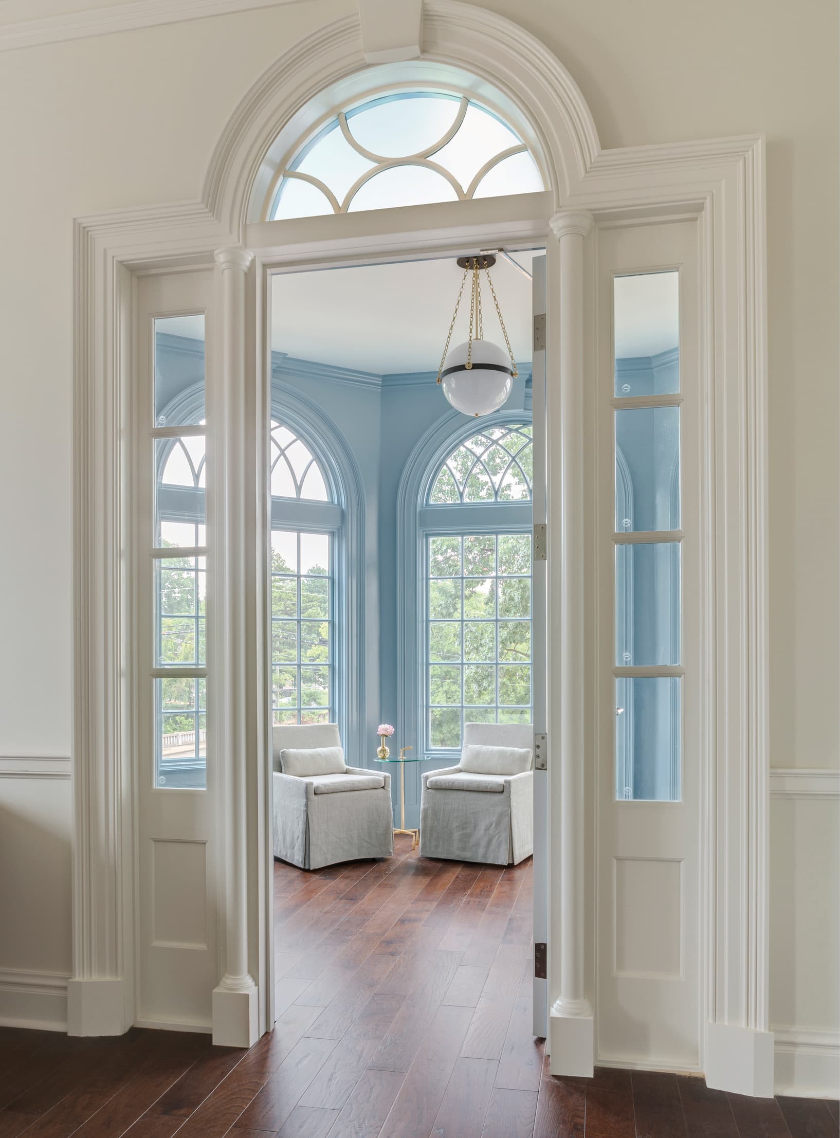 Doorway looking into a blue room with arched windows