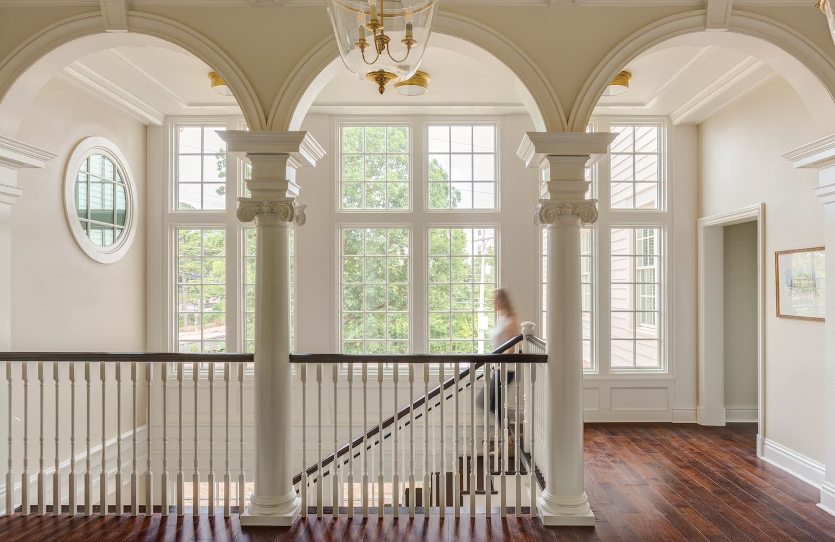 Stairway landing with large windows in background