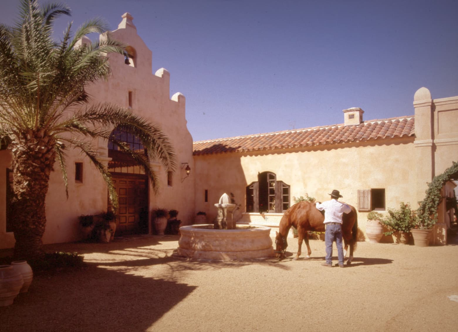 Man and his horse in a courtyard